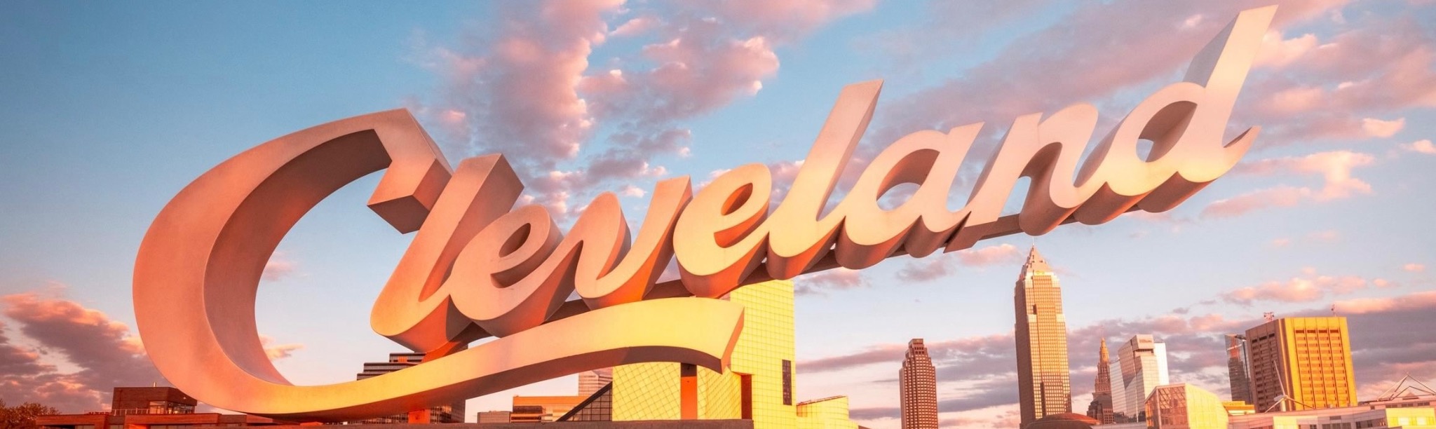Cleveland lettering above the city skyline at sunset